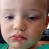 Oakley is registered to the contest to win money with this photo: toddler, child, face, expression, green_shirt, indoor, portrait, young_child, person, head, skin, hair, eyes, mouth, casual_clothing, closeup, contemplative, baby, young_boy, curly_hair