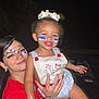 child, toddler, woman, face_paint, tattoos, smile, happy, night, holding, celebration, outdoor, person, red_shirt, white_bow, blue_and_white, face, portrait, cute, joy, together