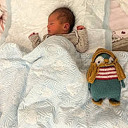 Théonor participe au concours pour gagner de l'argent avec cette photo : newborn, baby, sleeping, blanket, knitted_toy, plush, bed, soft, striped_clothing, cozy, infant, cute, child, indoors, quiet, resting, toy, patterned, peaceful, comfort