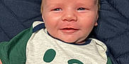 Abel is registered to the contest to win money with this photo: baby, blanket, blue_eyes, child, clothing, cute, face, good_vibes_only, green_sleeves, happy, head, infant, lying_down, person, quilted, skin, smiling, text, tshirt, winking_smiley