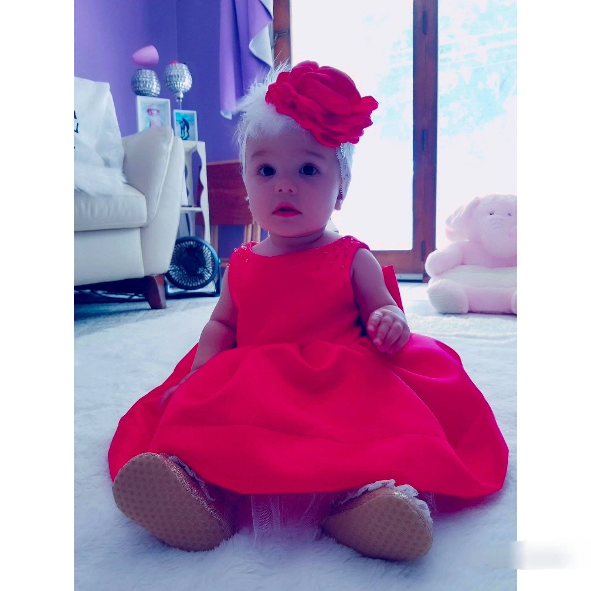 Luciana is registered to the contest to win money with this photo: baby, beanie, child, clothing, costume, dress, head, headgear, magenta, person, pink, play, plush, purple, sitting, smile, stuffed_toy, surprise, textile, toddler