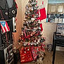 Frankie is registered to the contest to win money with this photo: candy_canes, christmas_tree, decorations, dog, festive, flag, floor, furniture, gifts, holiday, indoor, kitchen, lights, ornaments, presents, puerto_rican_flag, speaker, stockings, table, wall
