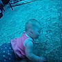 baby, baby_clothes, blue_tint, blur, carpet, carpet_pattern, child, crawling, floor, furniture, home, indoor, infant, person, pillow, pink_clothing, polka_dot, shoes, soft_surface, young_child