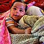 Josiah joined the competition — help win amazing prizes! baby, child, blanket, soft_texture, colorful, smiling, face, cute, indoors, comfort, warm, striped_clothing, toddler, cuddly, portrait, head, hand, happy, plush, cozy