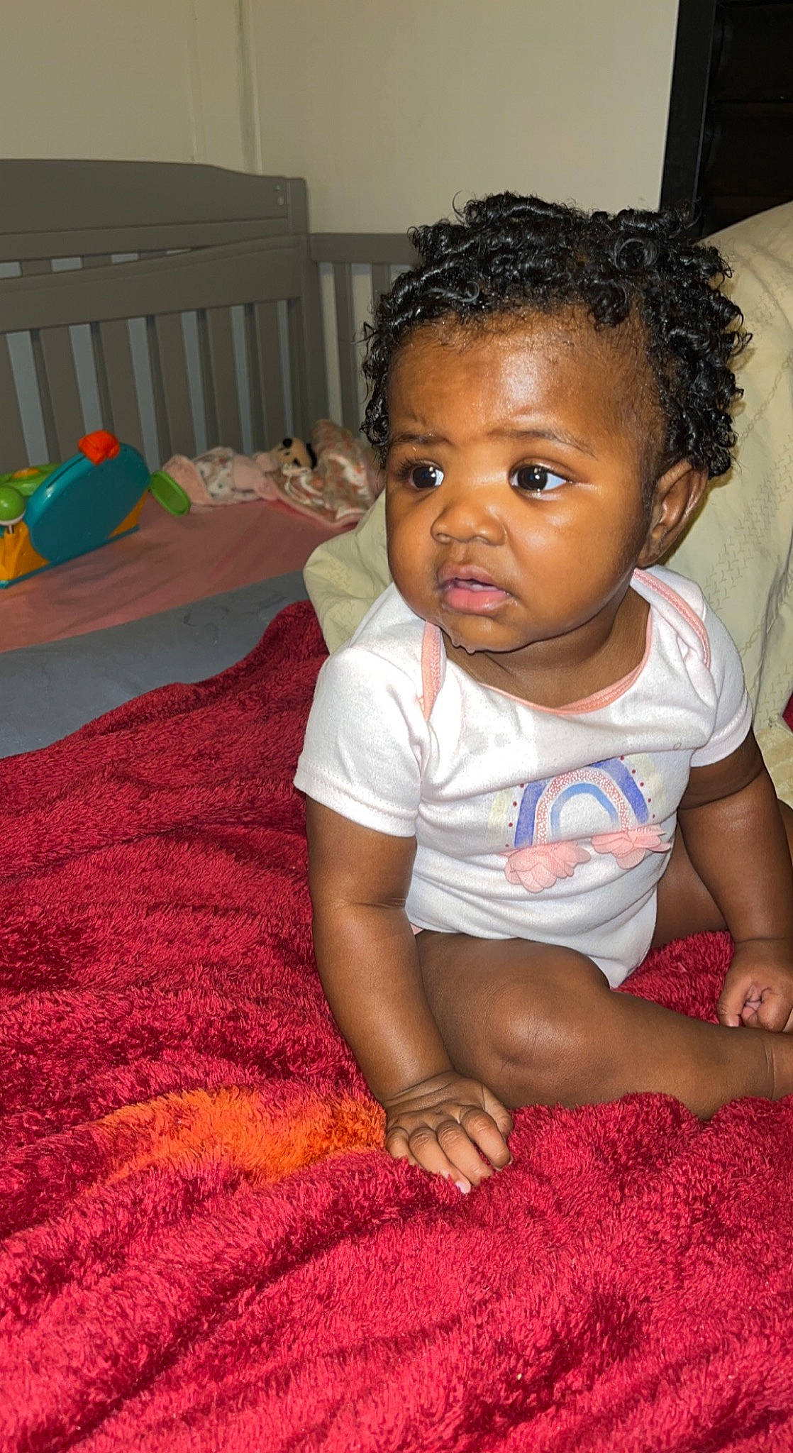 Lei'Yonna is registered to the contest to win money with this photo: adaptation, baby, baby_toddler_clothing, cheek, child, comfort, facial_expression, floor, flooring, fun, hairstyle, happy, head, nose, person, pink, sitting, skin, smile, t_shirt