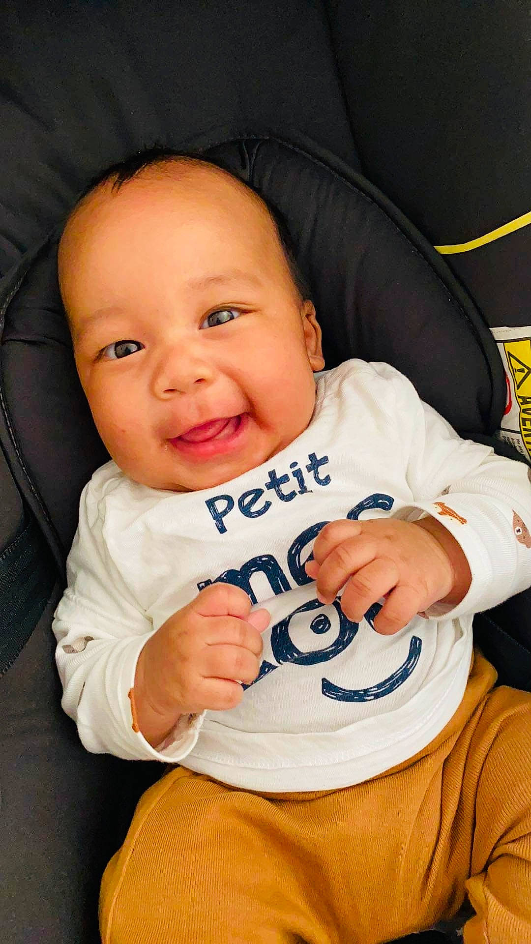 Issa participe au concours pour gagner de l'argent avec cette photo : baby, baby_in_car_seat, baby_toddler_clothing, cheek, child, comfort, facial_expression, finger, fun, gesture, happy, outerwear, person, product, skin, sleeve, smile, t_shirt, thumb, toddler