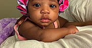 A Niylah is registered to the contest to win money with this photo: baby, bedroom, blanket, child, cozy, curious, cute, face, headwear, indoor, infant, person, pink_bonnet, plush, portrait, relaxing, skin, sleepwear, soft_toys, young_child
