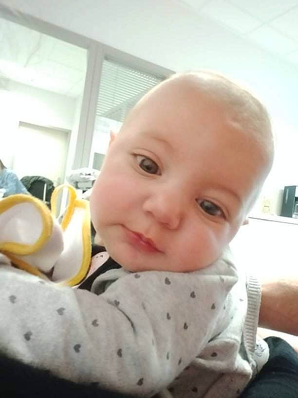 Inaya participe au concours pour gagner de l'argent avec cette photo : baby, baby_safety, baby_toddler_clothing, cheek, child, chin, comfort, fun, happy, linens, nose, person, room, sitting, skin, sleeve, smile, thumb, toddler