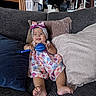 baby, child, infant, smiling, happy, portrait, indoor, couch, sofa, pillows, dress, floral_dress, headband, bow, rattle, toy, sitting, barefoot, home, furniture