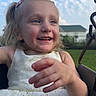 blonde_hair, casual, chain, child, clouds, daylight, dress, fun, girl, grass, happy, house, joy, outdoor, playground, portrait, sky, smile, summer, swing