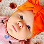 baby, infant, face, blue_eyes, orange_bow, headband, pink_clothing, halloween_theme, pumpkin, bat, spider, blanket, flower, orange_flower, cute, portrait, close_up, child, lying_down, soft_texture