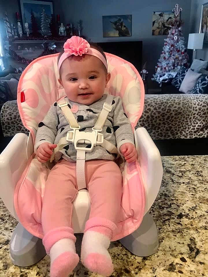 Lillyana is registered to the contest to win money with this photo: baby, baby_toddler_clothing, carmine, child, comfort, costume, fun, happy, human_body, human_leg, knee, lap, person, personal_protective_equipment, pink, sitting, skin, sleeve, smile, thigh