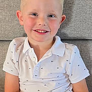 Enzo participe au concours pour gagner de l'argent avec cette photo : child, boy, smiling, blond_hair, white_shirt, polo_shirt, sitting, couch, indoor, happy, portrait, casual_clothing, young, cute, face, person, relaxed, light, skin, friendly