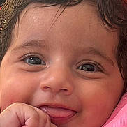 Dina a rejoint le concours — aidez-le/la à gagner de superbes lots ! baby, close_up, face, smile, tongue, hand, pink_clothing, cute, infant, child, skin, eyelashes, cheeks, happy, portrait, young, person, expression, indoors, warm