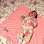 Dina participe au concours pour gagner de l'argent avec cette photo : baby, bedspread, blanket, child, colorful_clothing, cozy, cute, fleece_outfit, floral_pattern, happy, indoors, infant, lying_down, person, pink_blanket, portrait, smiling, socks, soft_texture, young_child