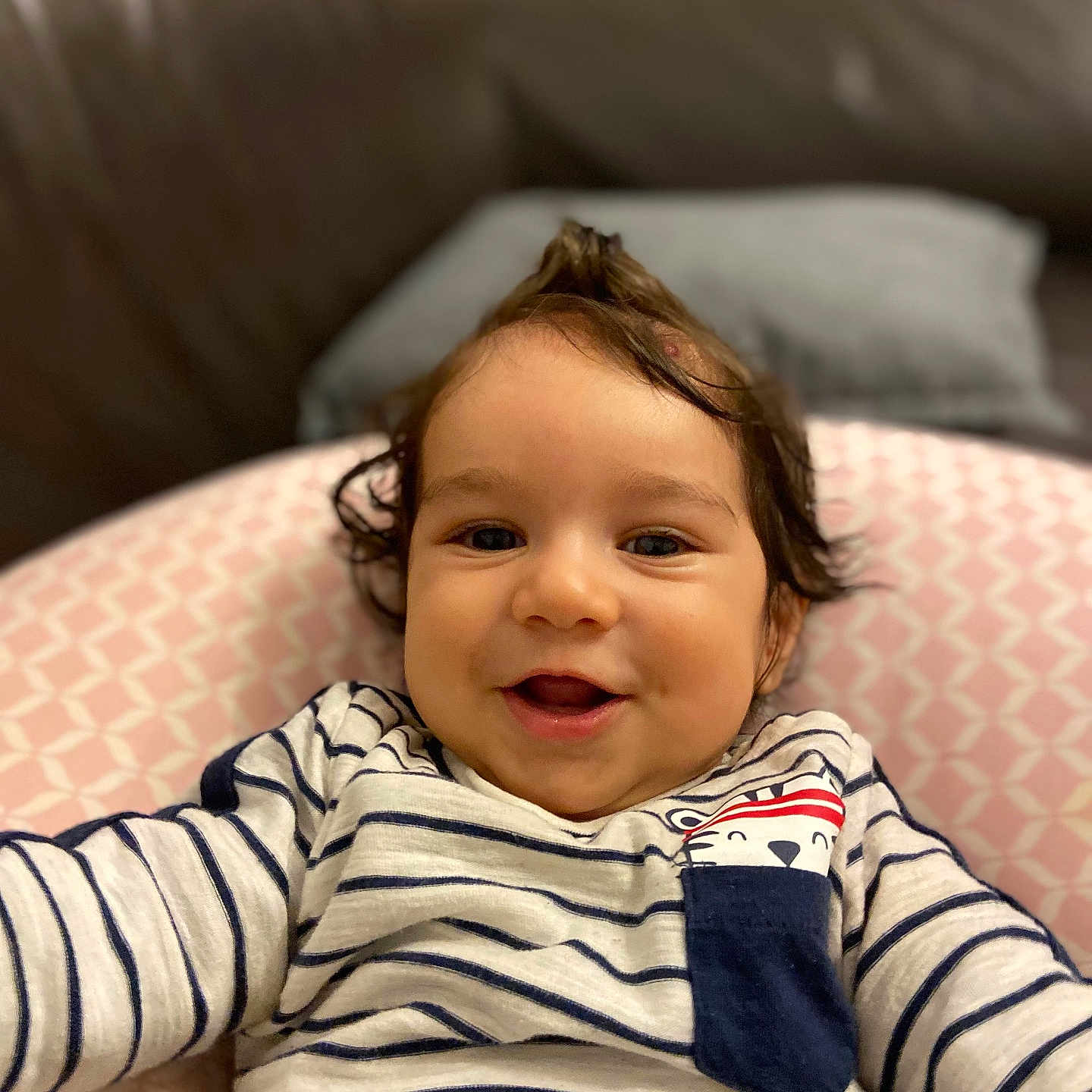 Ekam Singh participe au concours pour gagner de l'argent avec cette photo : baby, child, closeup, clothing, cushion, cute, face, happy, home, indoor, infant, mohawk, person, pink_pattern, portrait, relaxed, smiling, soft_lighting, striped_shirt, toddler