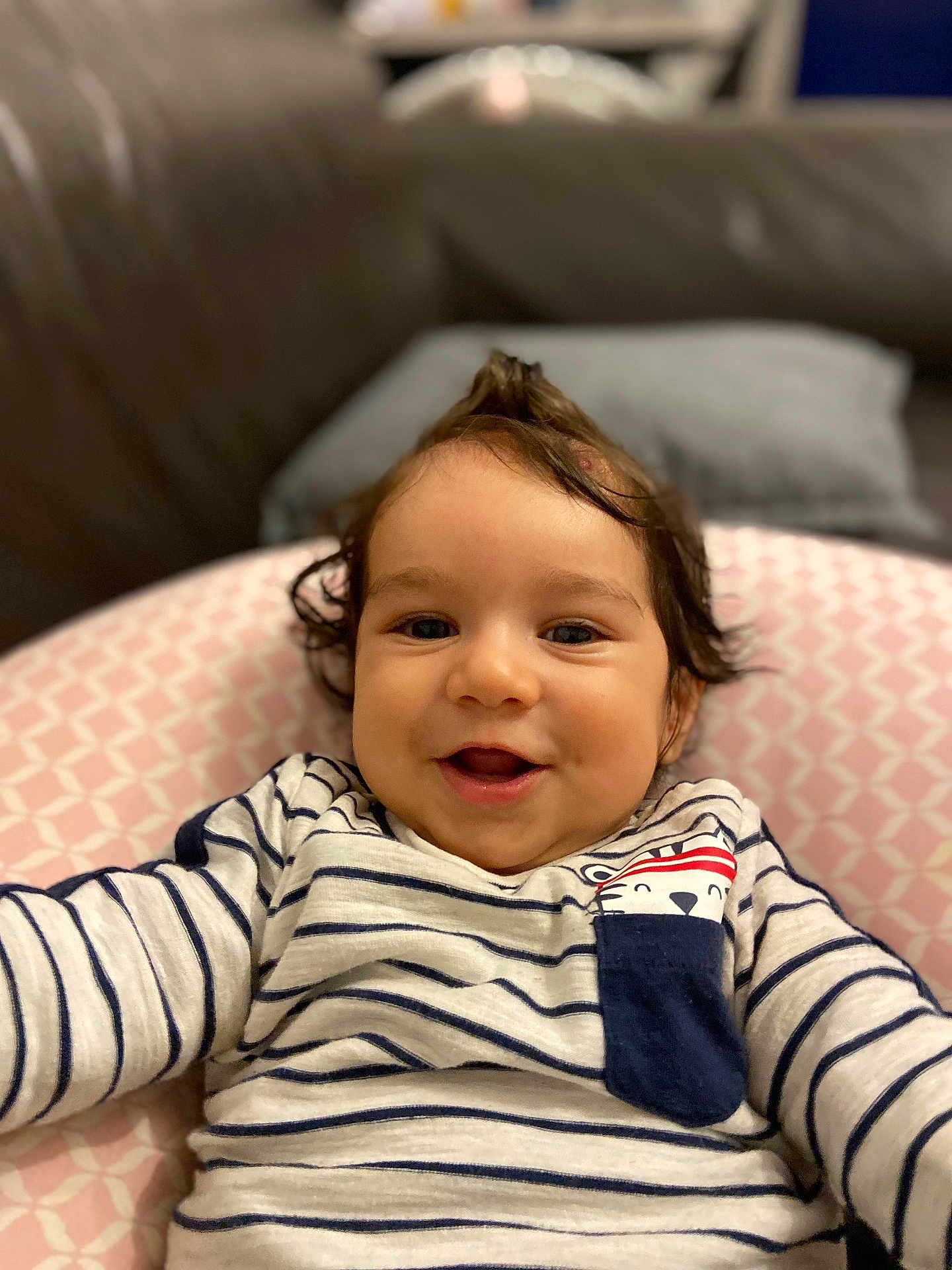 Ekam Singh participe au concours pour gagner de l'argent avec cette photo : baby, child, closeup, clothing, cushion, cute, face, happy, home, indoor, infant, mohawk, person, pink_pattern, portrait, relaxed, smiling, soft_lighting, striped_shirt, toddler