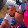 Danny joined the competition — help win amazing prizes! baby, newborn, sleeping, adult, kiss, glasses, headband, indoor, car_seat, couch, floor, love, affection, close_up, person, clothing, text_overlay, hand, foot, skin