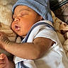 Danny joined the competition — help win amazing prizes! baby, sleeping, blue_hat, white_clothing, blanket, couch, video_call, face, infant, child, indoors, relaxing, cozy, portrait, person, soft_texture, smiling_adult, technology, screen, communication