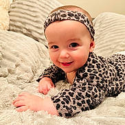 Livia participe au concours pour gagner de l'argent avec cette photo : baby, infant, smiling, leopard_print, headband, blanket, soft_texture, couch, cute, child, happy, portrait, clothing, toddler, indoor, face, hand, skin, warm_light, cozy