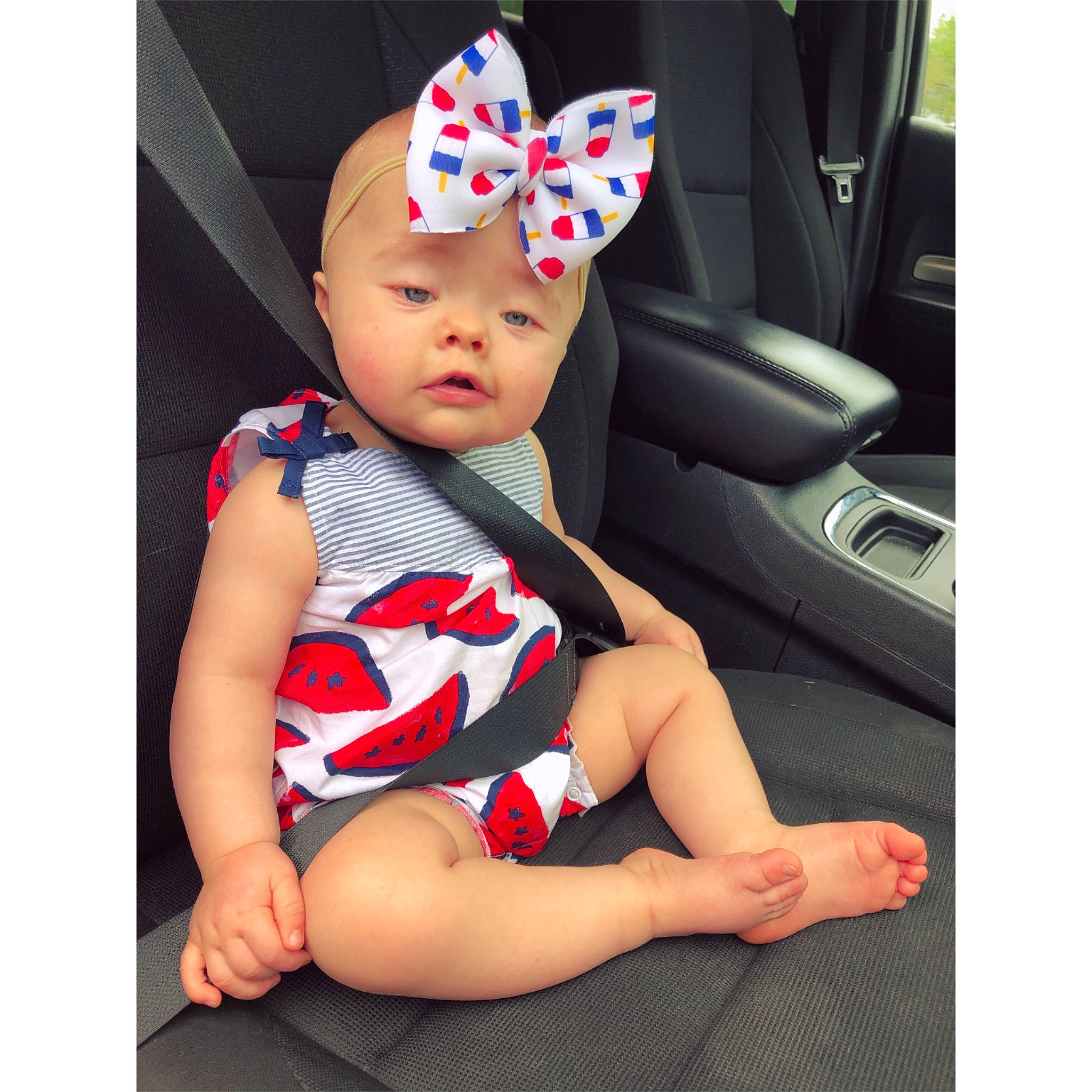 Lily Rose is registered to the contest to win money with this photo: arm, auto_part, baby, baby_products, baby_toddler_clothing, cap, car, car_seat, costume_hat, family_car, fashion_accessory, happy, head, headwear, pattern, person, product, sleeve, steering_wheel, thumb