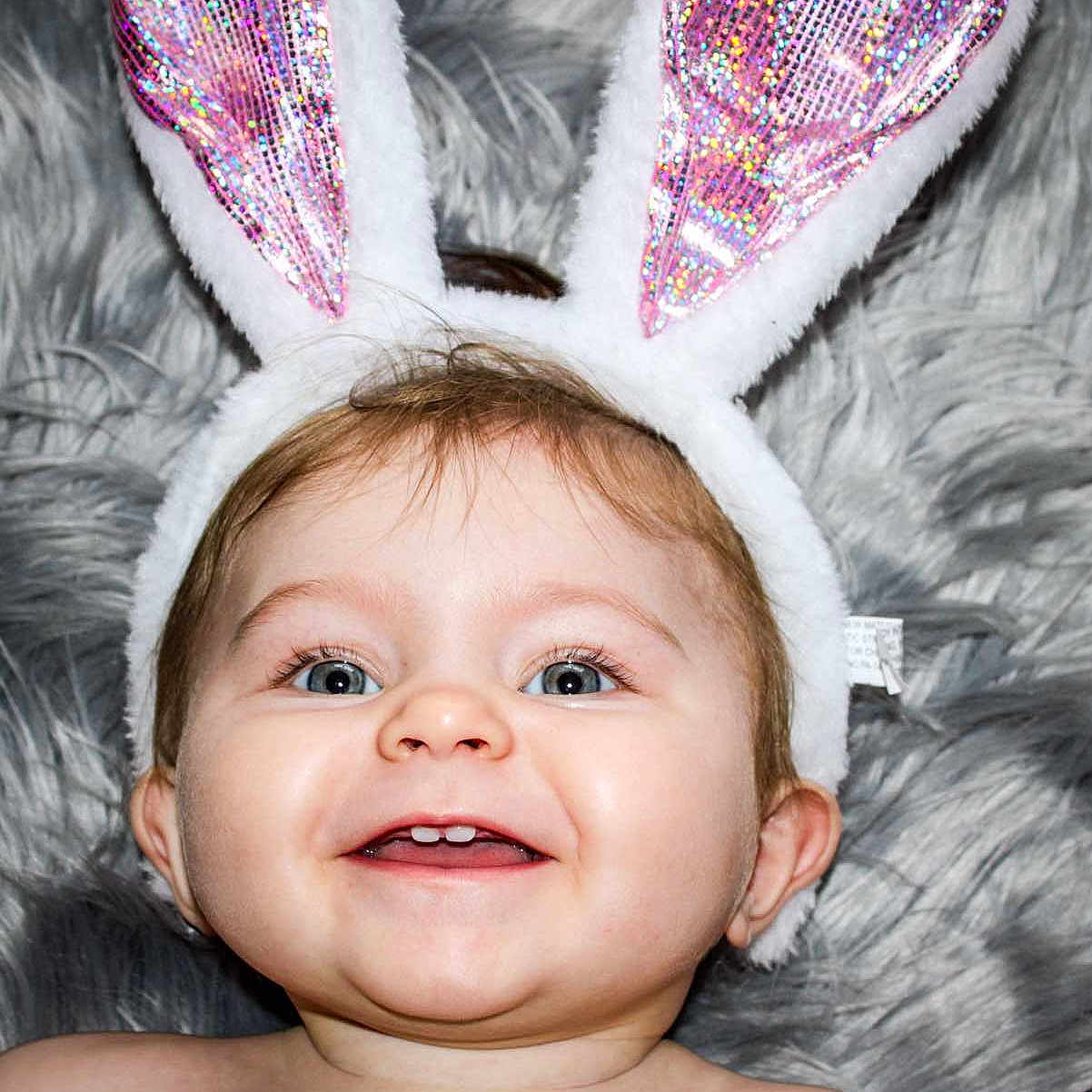 Layce is registered to the contest to win money with this photo: adorable, baby, blue_eyes, bunny_ears, cheerful, child, closeup, costume, cute, expression, face, fur_blanket, happy, headwear, infant, pink, portrait, skin, smile, white