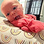 Clementine is registered to the contest to win money with this photo: baby, infant, tongue, pillow, pink_clothing, face, eyes, indoor, curious, closeup, pattern, window, curtain, soft_light, skin, head, expression, child, cute, laying_down