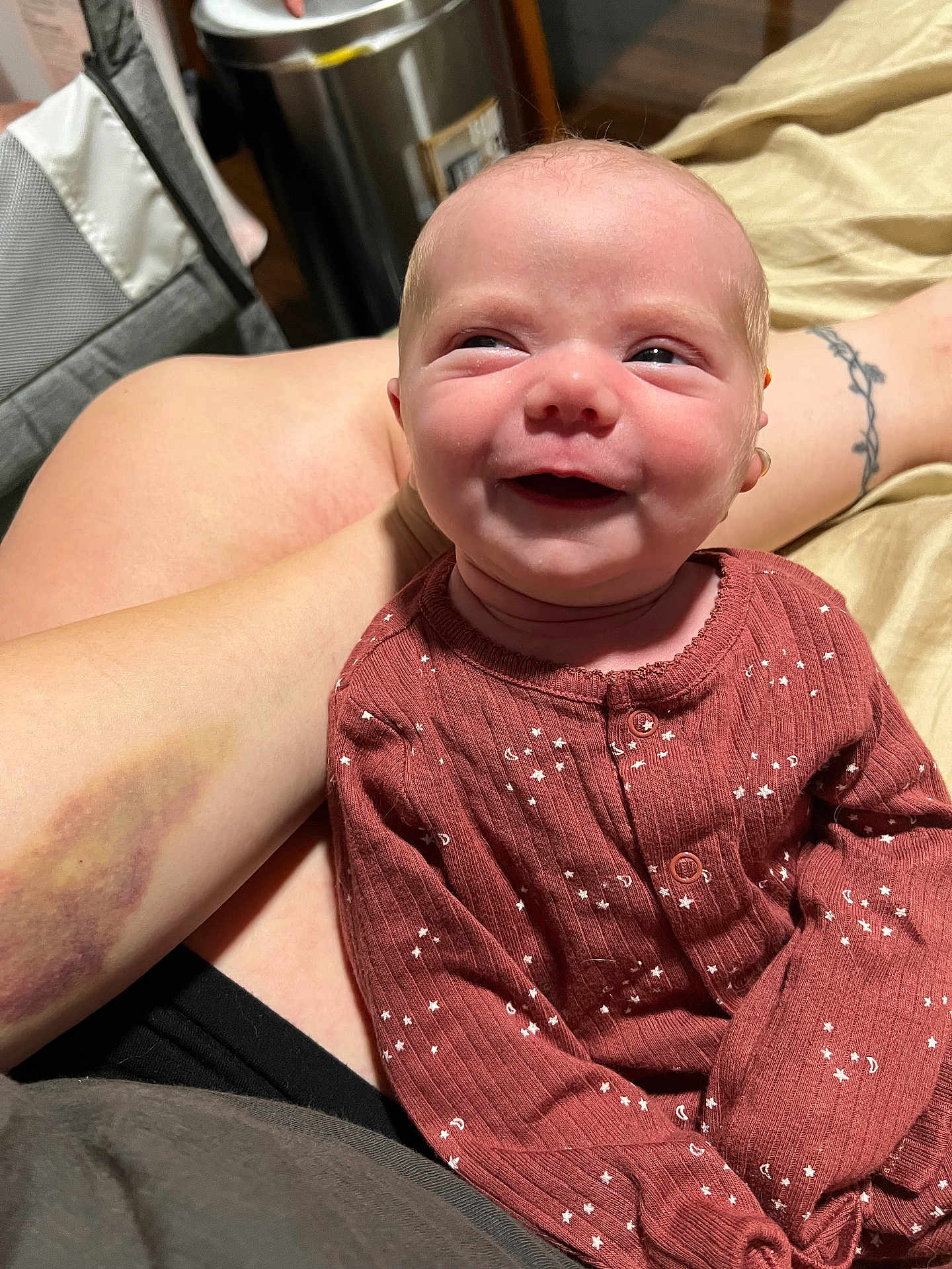 Clementine is registered to the contest to win money with this photo: baby, smile, infant, clothing, onesie, person, tattoo, arm, bruise, indoor, happy, face, skin, human, candid, cute, sitting, closeup, expression, comfort