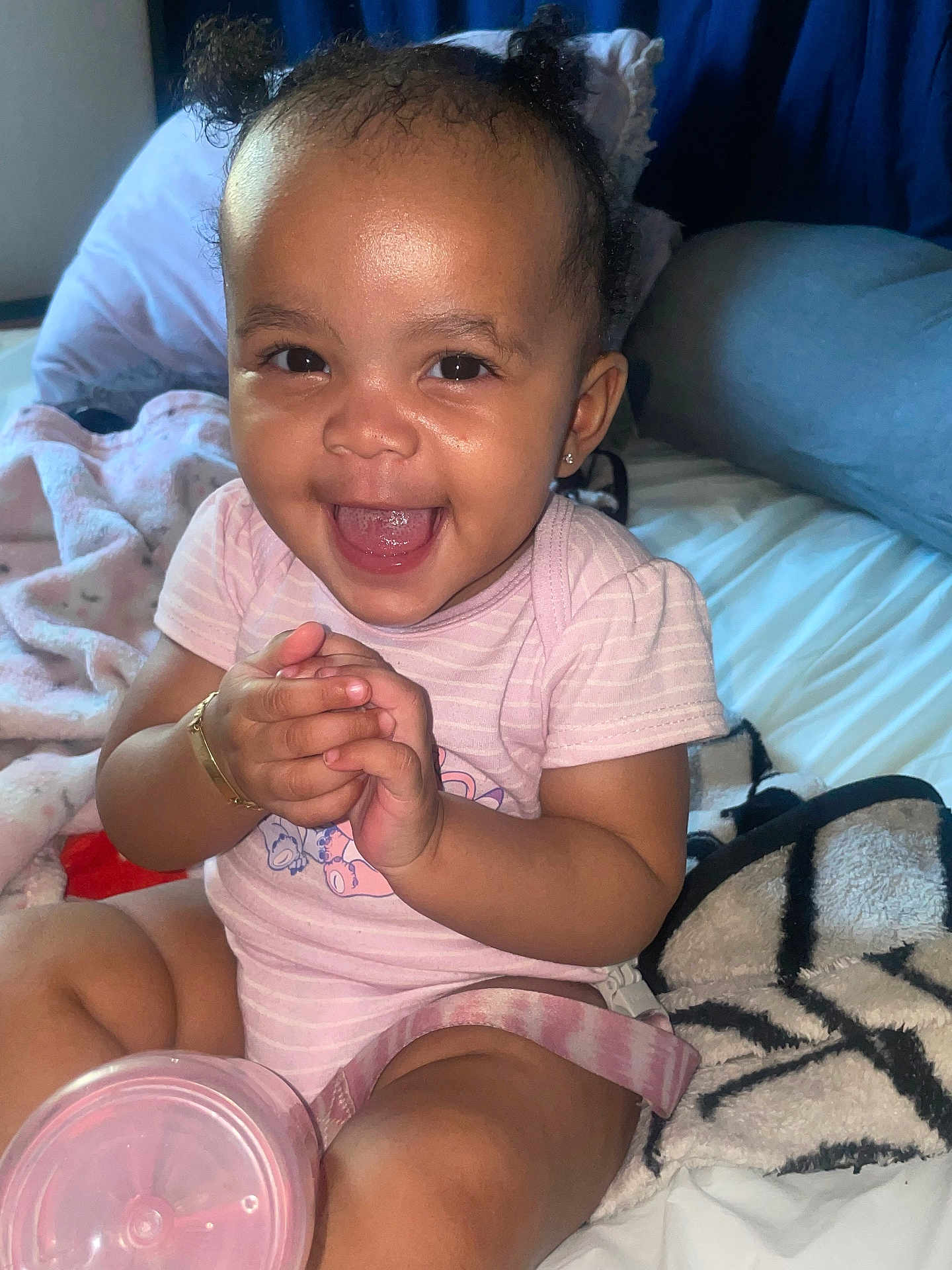 Midior joined the competition — help win amazing prizes! baby, child, smiling, clapping, pigtails, pink_clothing, bracelet, earrings, blanket, bed, sippy_cup, indoor, happy, cute, person, toddler, infant, skin, face, hands