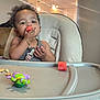 toddler, child, high_chair, watermelon, food, eating, toy, turtle, indoor, home, lighting, ceiling_fan, kitchen, furniture, person, cute, snack, baby, seat, bracelet