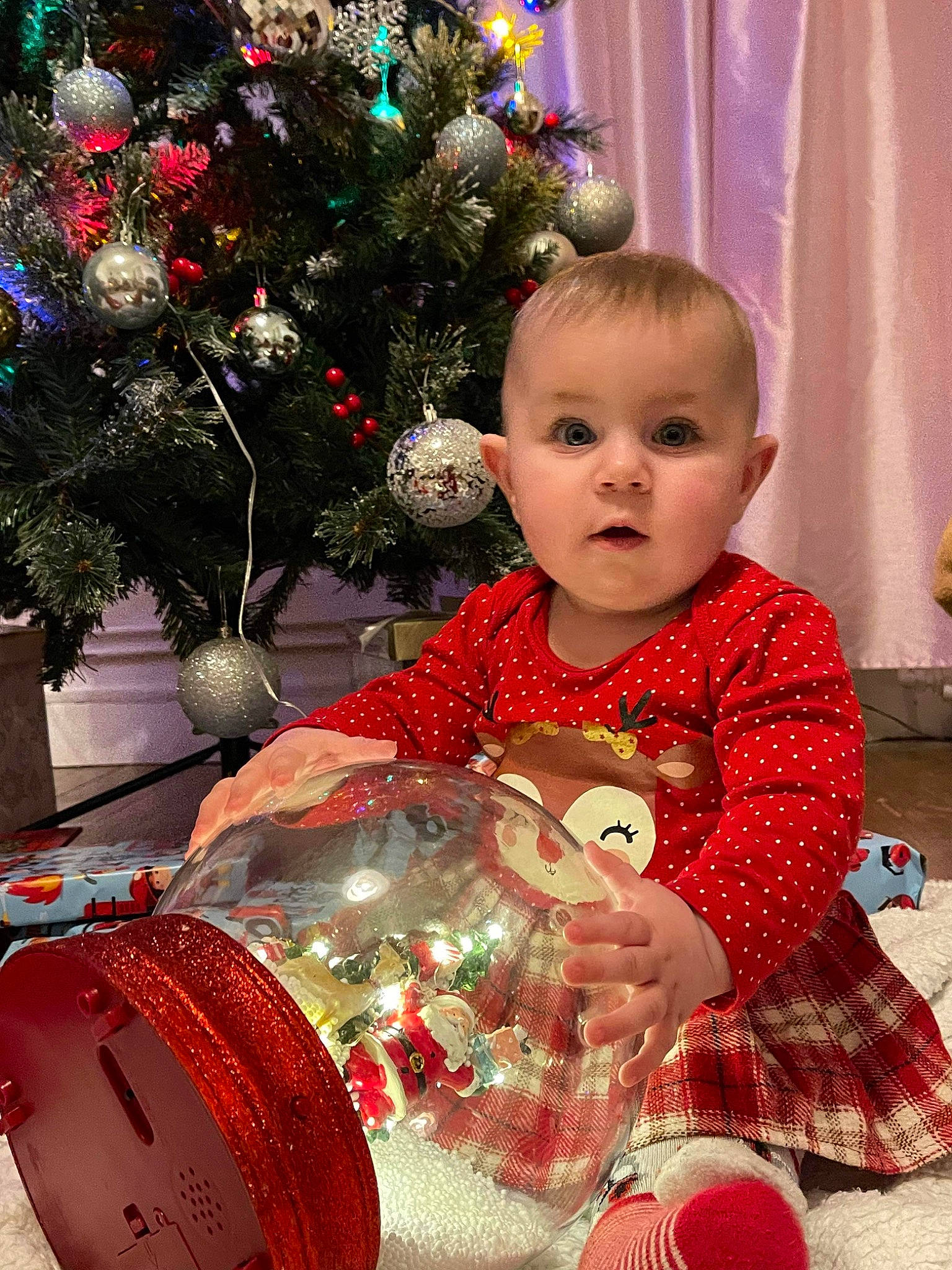 Alicia a rejoint le concours — aidez-le/la à gagner de superbes lots ! baby_toddler_clothing, beauty, child, christmas, christmas_decoration, christmas_eve, christmas_ornament, christmas_tree, conifer, curtain, event, happy, holiday, holiday_ornament, ornament, person, plant, red, room, surprise