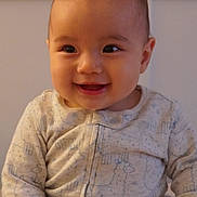 Mia is registered to the contest to win money with this photo: baby, child, smiling, face, onesie, clothing, infant, cute, happy, portrait, indoor, person, young, soft_lighting, patterned_clothing, sitting, closeup, head, skin, cheerful