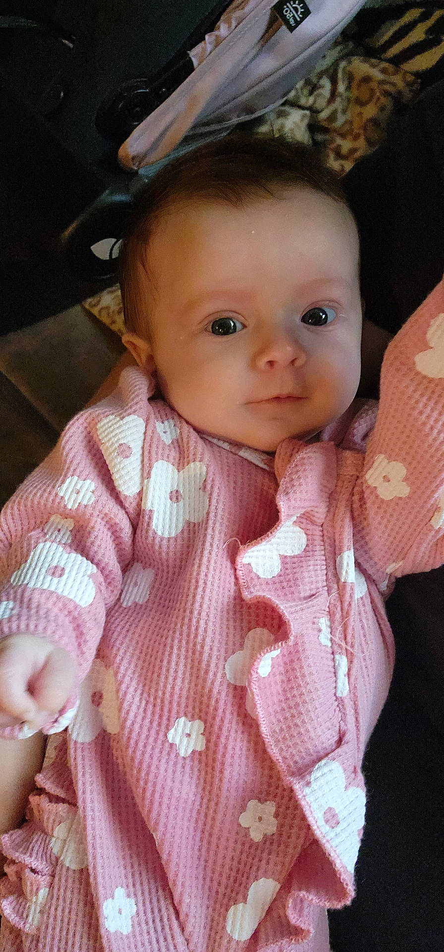 baby, child, closeup, cozy, cute, expression, eyes, face, floral_pattern, hand, indoor, infant, newborn, onesie, person, pink_clothing, portrait, soft_lighting, warm, young