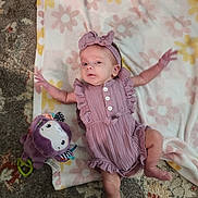 Alivia joined the competition — help win amazing prizes! baby, infant, child, blanket, plush_toy, purple, mauve, headband, romper, carpet, floral_pattern, cute, lying_down, indoor, soft_toy, person, clothing, small_child, relaxed, baby_girl