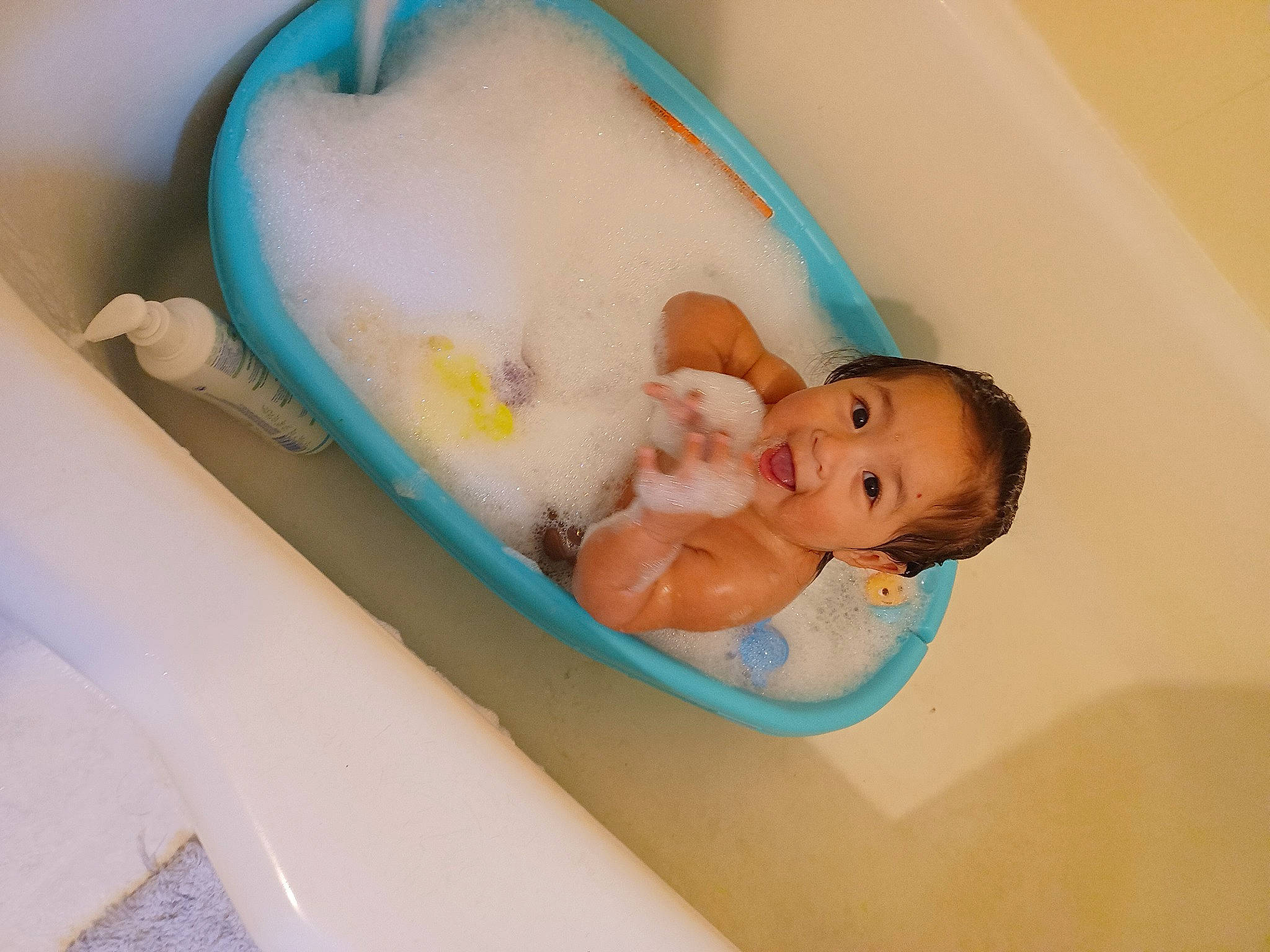 Elle is registered to the contest to win money with this photo: aqua, arm, baby, baby_bathing, baby_products, baby_safety, bathing, bathtub, child, comfort, fluid, fun, hand, infant_bed, leisure, person, personal_care, plumbing_fixture, room, skin