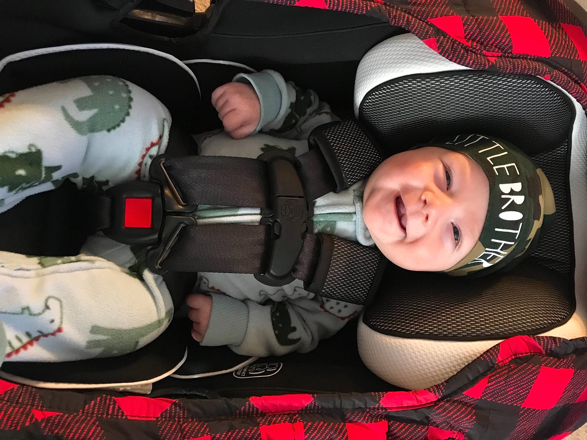 William is registered to the contest to win money with this photo: auto_part, automotive_design, automotive_wheel_system, baby, baby_carriage, baby_toddler_clothing, car_seat, child, comfort, finger, fun, hat, headgear, headwear, mouth, pattern, person, product, red, smile