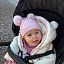 baby, child, stroller, hat, pom_poms, jacket, white, pink, tongue_out, outdoor, cold_weather, cute, playful, seat_belt, fabric, knit, person, face, blue_eyes, hood