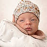 newborn, baby, blanket, hat, floral, sleepy, face, portrait, soft_lighting, cozy, infant, cute, wrapped, warm, expression, headwear, child, skin, closeup, indoors