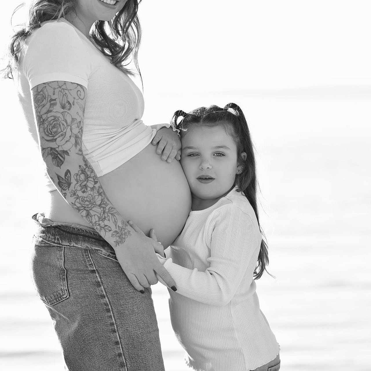 Swann a rejoint le concours — aidez-le/la à gagner de superbes lots ! black_and_white, casual_clothing, child, embrace, emotion, family, holding_hands, jeans, long_hair, love, mother_and_daughter, nature, outdoor, pigtails, portrait, pregnant, smile, tattoo, water, woman