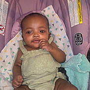 Alexis Spence joined the competition — help win amazing prizes! baby, child, infant, car_seat, purple, blanket, green_outfit, patterned_blanket, blue_cloth, cute, relaxed, indoors, portrait, young_child, sitting, person, clothing, fabric, soft, comfortable