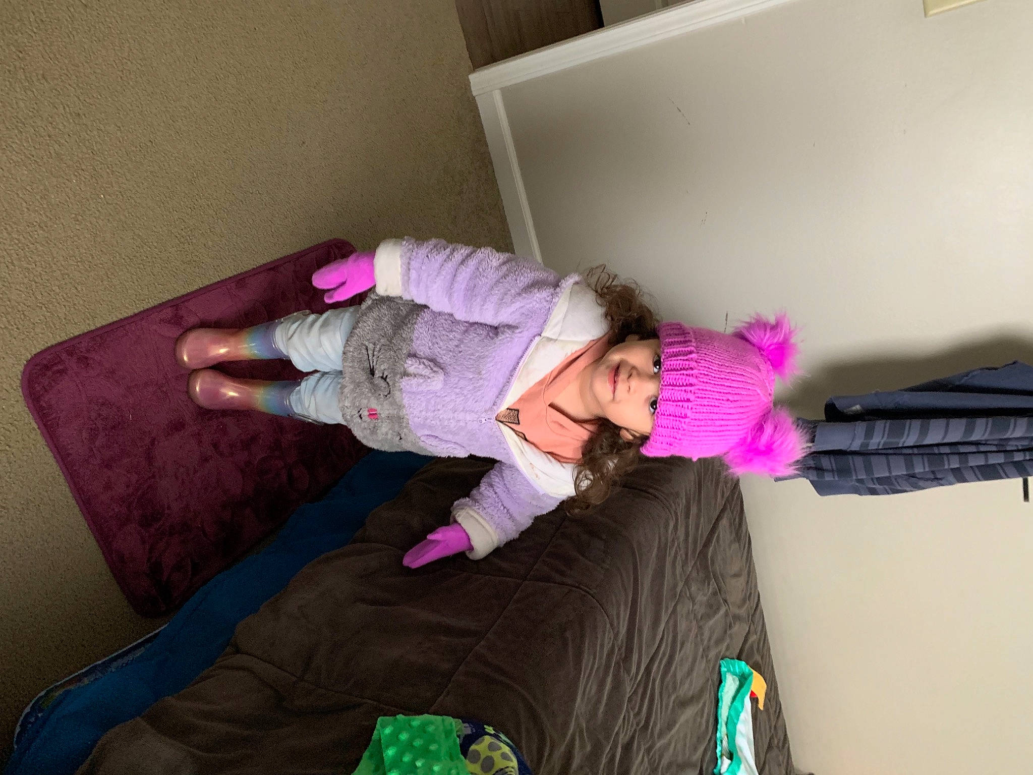 Issabella joined the competition — help win amazing prizes! bed, bedroom, child, comfort, floor, flooring, fun, hardwood, headwear, knee, linens, magenta, person, pink, purple, room, shelf, sitting, sock, thigh