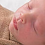 baby, sleeping, close_up, face, skin, blanket, knitted, peaceful, infant, child, soft, cute, resting, mouth, nose, eyelashes, cheeks, portrait, newborn, serene