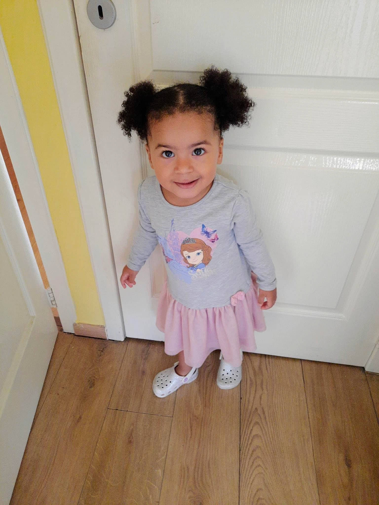 Naëlle participe au concours pour gagner de l'argent avec cette photo : baby_toddler_clothing, dress, face, fashion_design, floor, flooring, happy, hardwood, human_leg, joy, laminate_flooring, magenta, pattern, person, skin, sleeve, smile, toddler, varnish, wood