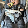 baby, infant, high_chair, pacifier, toy, blanket, clothing, striped_outfit, face, person, indoor, seat, comfort, child, baby_toy, baby_clothes, home, furniture, soft_toy, straps