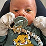 Mathéo D Adamo participe au concours pour gagner de l'argent avec cette photo : baby, beads, blue_eyes, cartoon_lion, child, closeup, clothing, cute, face, green_shirt, hand, indoor, infant, lying_down, mittens, newborn, pacifier, pacifier_clip, person, soft_lighting