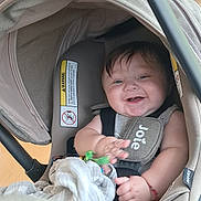 Ezequiel is registered to the contest to win money with this photo: baby, car_seat, smiling, indoor, child, toy, blanket, fabric, happy, infant, seatbelt, head_support, clothing, person, face, hand, protection, cushion, canopy, bright