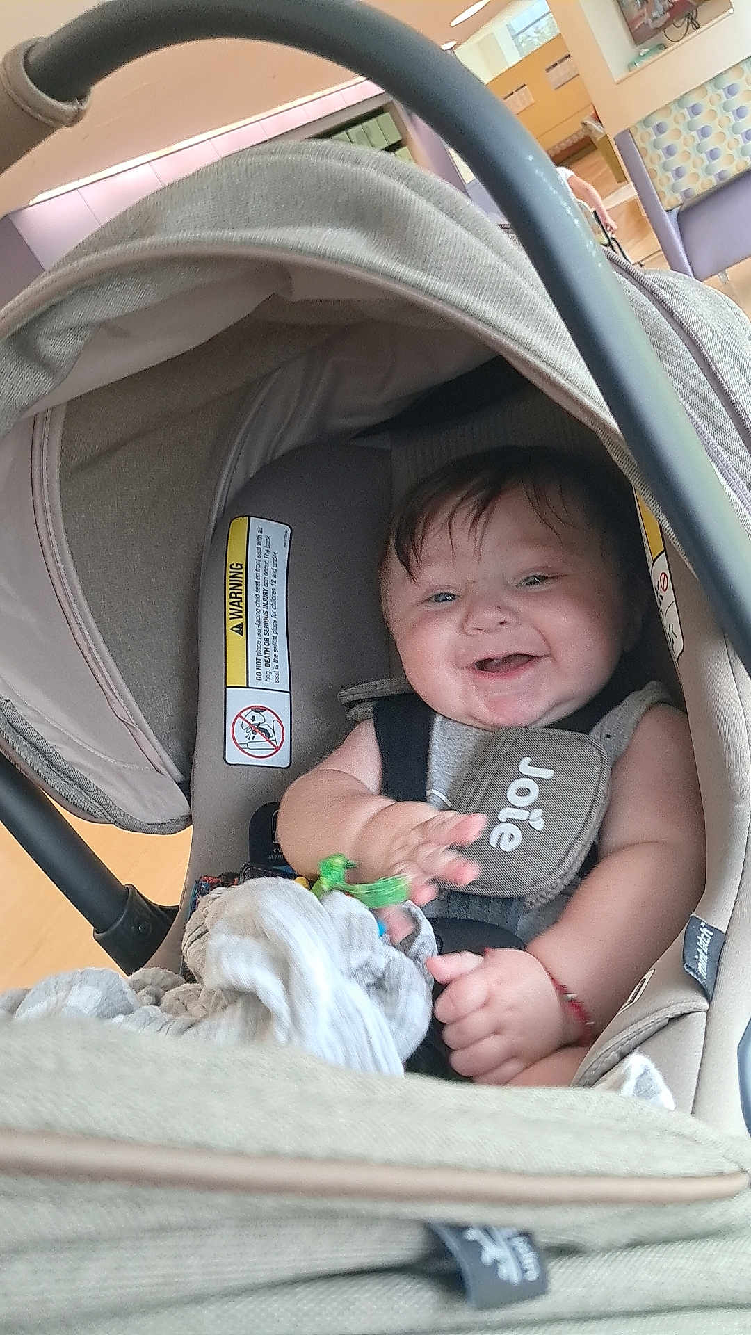 Ezequiel is registered to the contest to win money with this photo: baby, car_seat, smiling, indoor, child, toy, blanket, fabric, happy, infant, seatbelt, head_support, clothing, person, face, hand, protection, cushion, canopy, bright