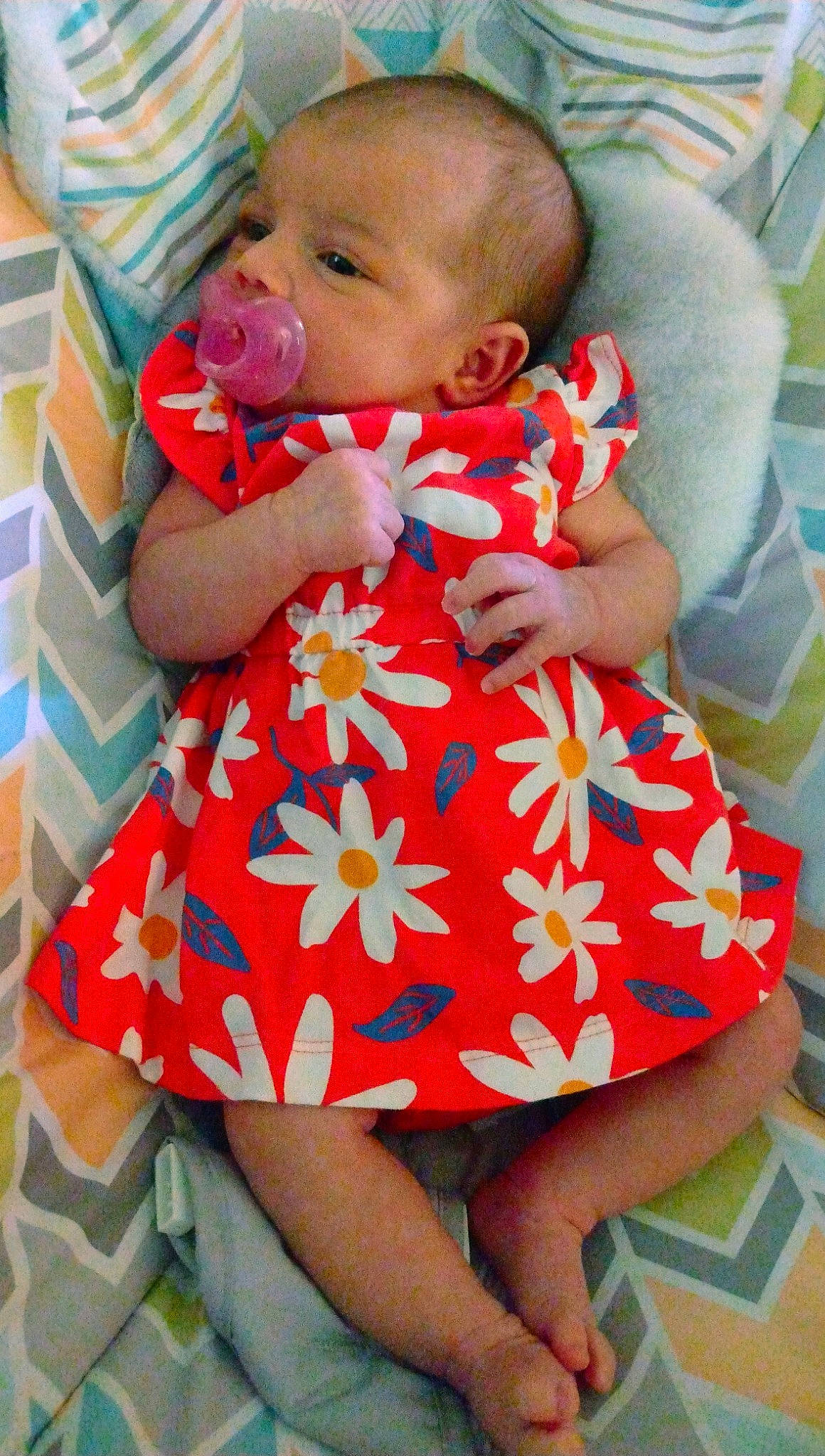 A'Riyah is registered to the contest to win money with this photo: baby, baby_products, baby_toddler_clothing, cheek, child, comfort, dress, finger, happy, linens, mouth, nail, orange, pattern, person, pink, red, skin, sleeve, thigh