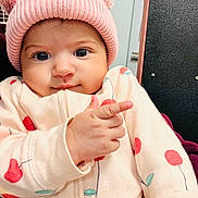 Ainara joined the competition — help win amazing prizes! baby, child, pink_hat, knit_hat, bear_ears, pointing, cherry_pattern, cute, smiling, indoor, cozy, clothing, face, hand, person, portrait, young_child, infant, warm, expression