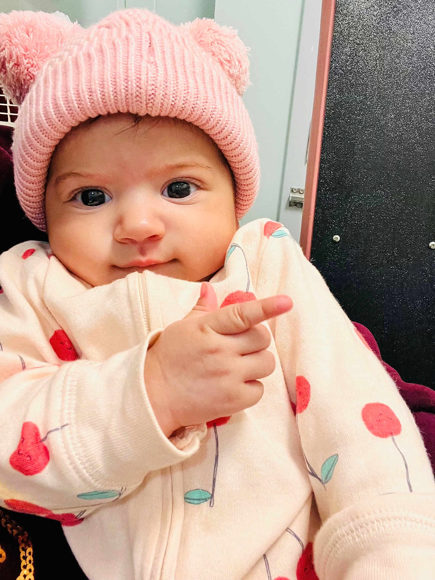 Ainara joined the competition — help win amazing prizes! baby, child, pink_hat, knit_hat, bear_ears, pointing, cherry_pattern, cute, smiling, indoor, cozy, clothing, face, hand, person, portrait, young_child, infant, warm, expression